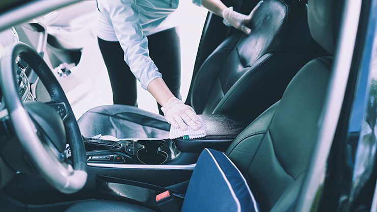 persona limpiando el coche con guantes