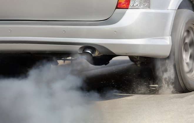 Humo negro saliendo del tubo de escape de un coche.