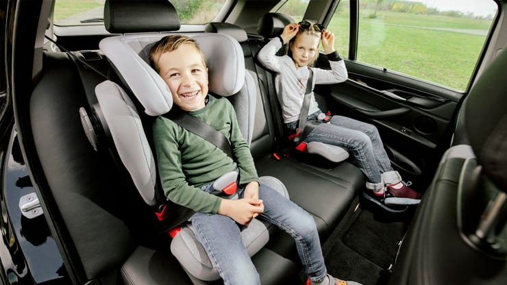 niños en un coche con sillita infantil