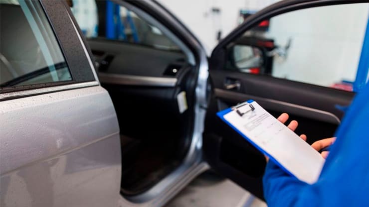 técnico de ITV revisando un coche